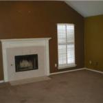 Living room with fireplace opens to kitchen