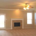 Living area with cozy fireplace opens to covered patio.